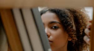 Mulher entre livros escondendo suas feridas emocionais